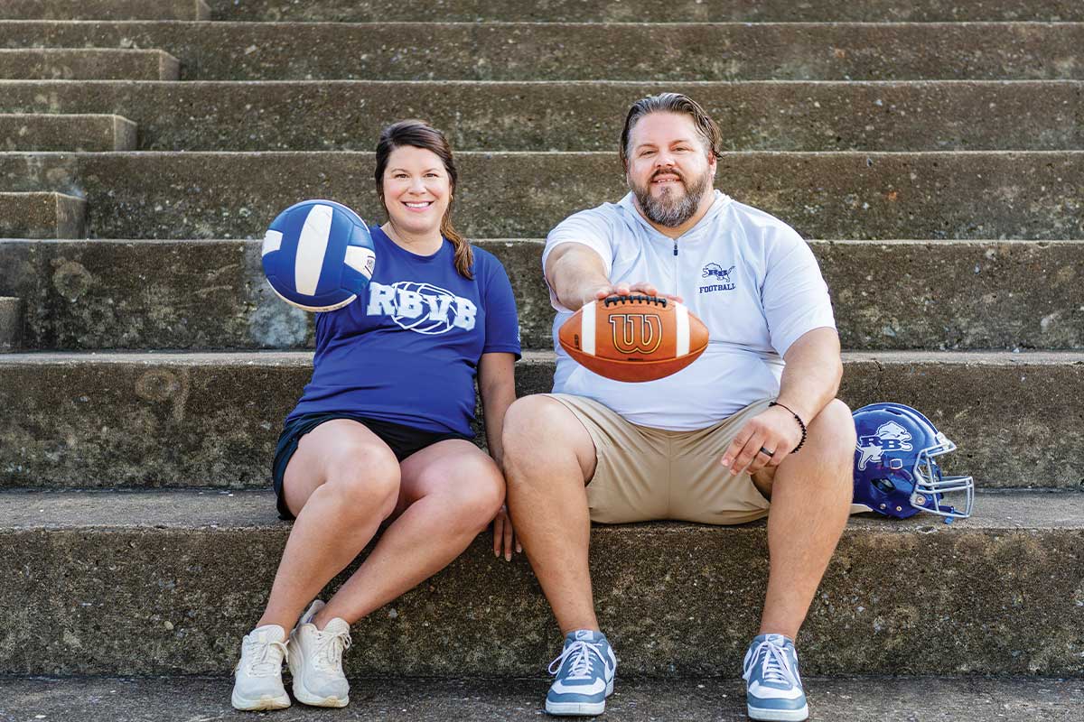 coaches holding balls on concrete bleachers