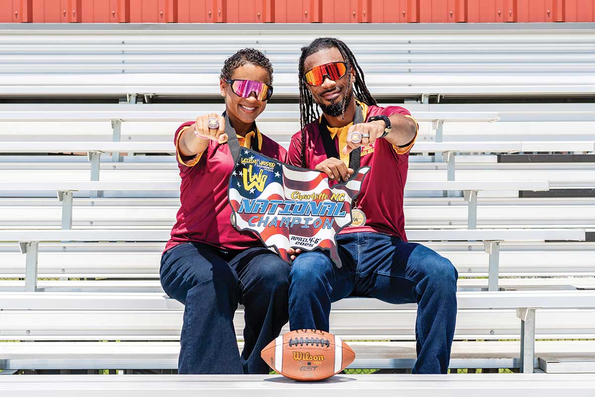 smiling coaches with championship rings on bleachers