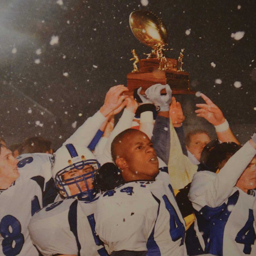 Football Players holding up trophy and cheering